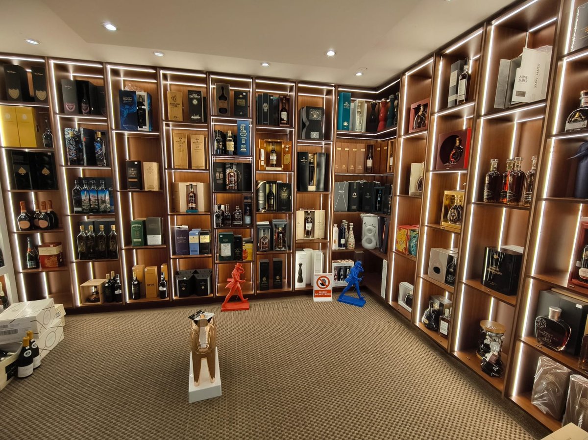 Large display room with floor-to-ceiling wooden shelving units filled with collectible items, figurines, and memorabilia