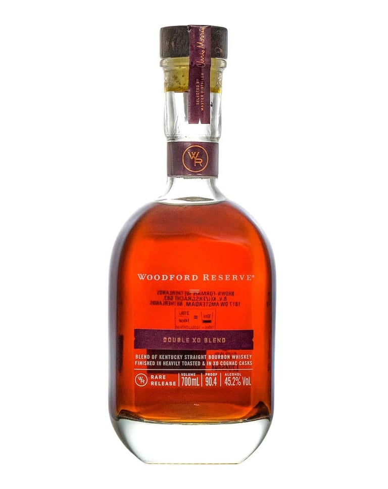 Bottle of Woodford Reserve Double Oaked bourbon whiskey with amber liquid and burgundy ribbon around cork