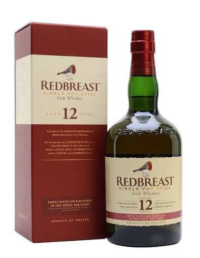 Redbreast 12 year old Irish single pot still whiskey bottle next to its burgundy and cream colored box packaging